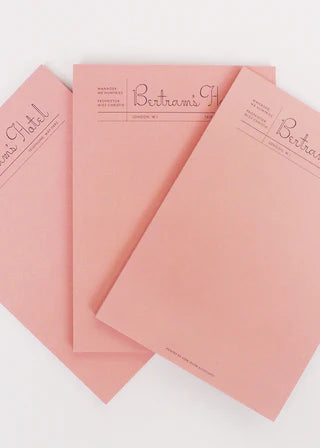 Set of pink notebooks with 'Bertram's' branding on a white background