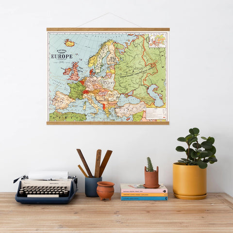 Map of Europe on a wall above a desk with a typewriter, books, and plants.
