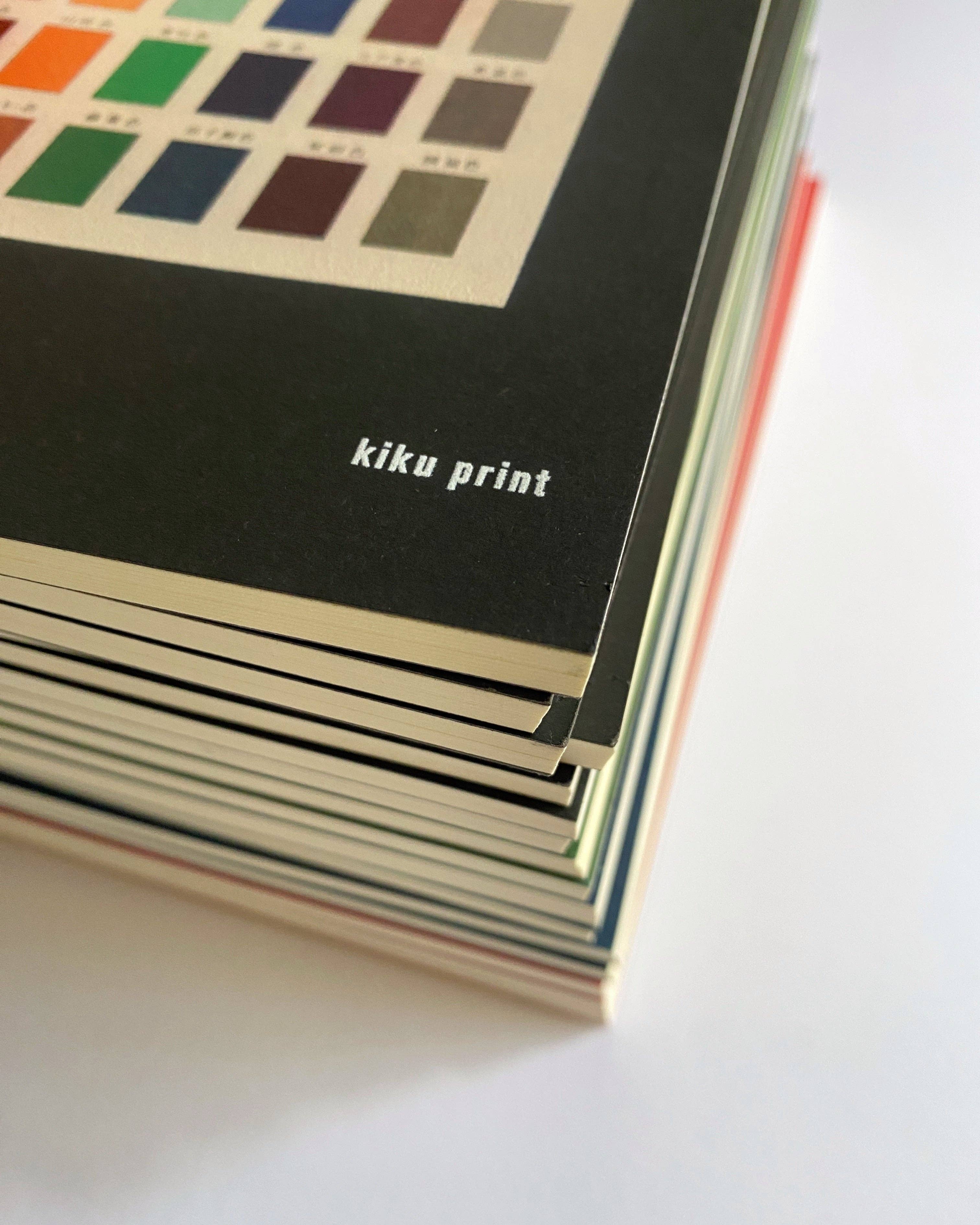 Stack of books with 'kiku print' branding on a white background