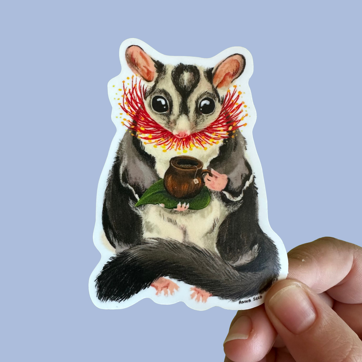 Sticker of a sugar glider holding a cup against a light purple background