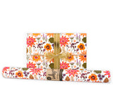 Floral-patterned gift wrap with a gold ribbon on a white background