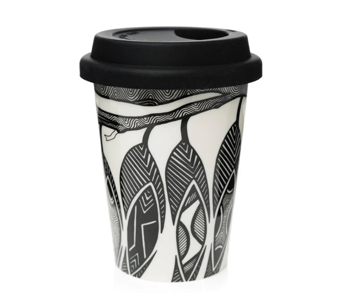 A reusable travel tumbler with a black lid, featuring a black and white graphic pattern of stylized faces and abstract line art, shown on a plain white background.