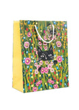 A yellow paper gift bag with a black cat in a field of flowers by Niaski