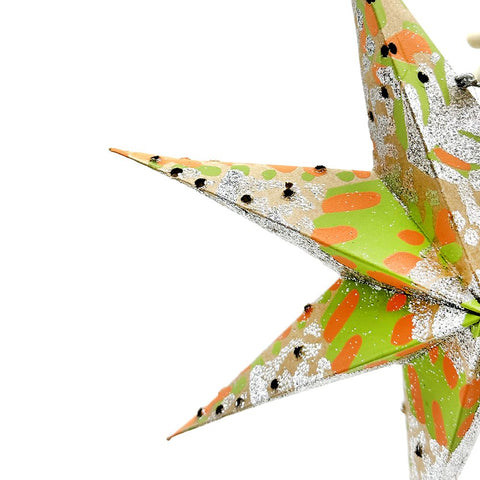 Decorative star-shaped lantern with green, orange, and silver design on a white background