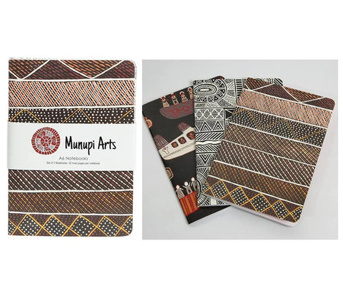 Three notebooks with different designs on a white background, featuring the brand 'Munupi Arts'.