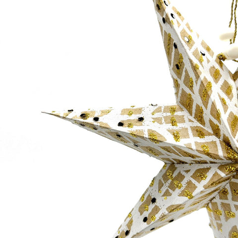 Decorative star ornament with gold and black pattern on a white background