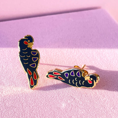 Bird-shaped earrings on a pink background
