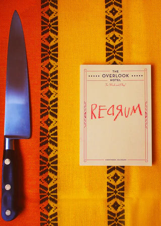 Knife and book titled 'Regain' on a patterned orange surface