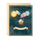 Greeting card with space-themed illustration of planets and sun, featuring a baby in a stroller under a banner that says 'Welcome Little Star'.